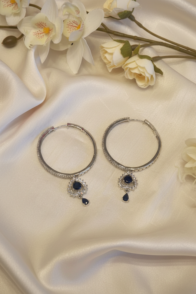 Navy CZ hoop earrings flat lay on champagne satin